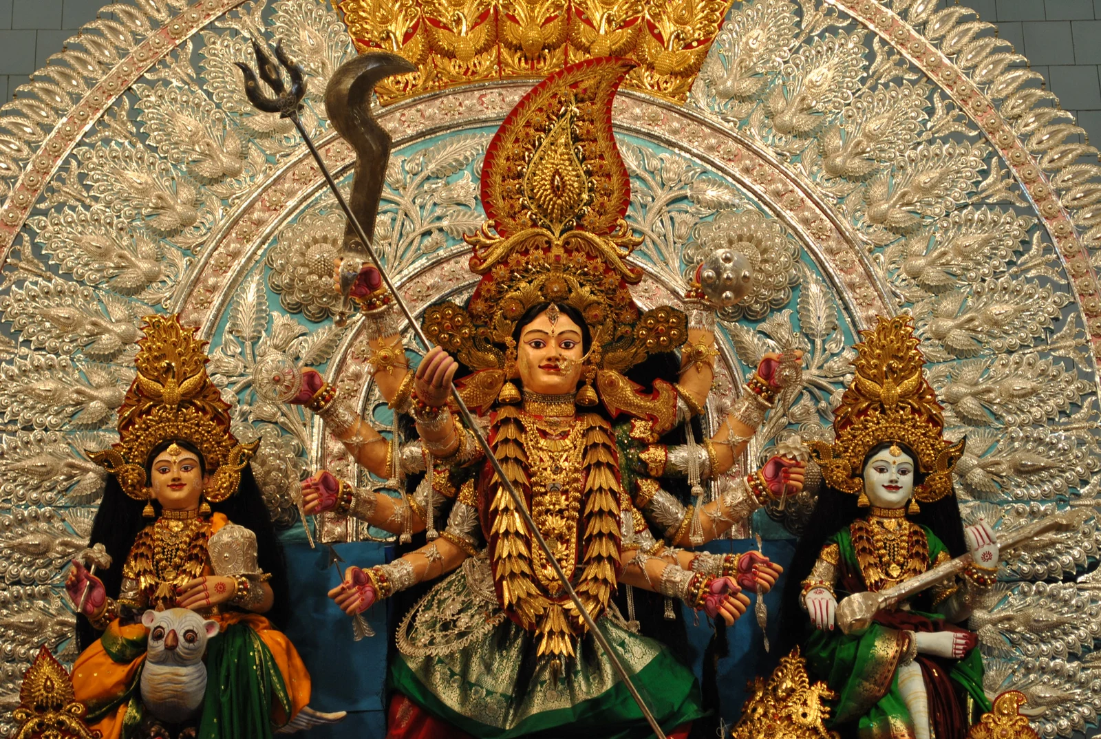 Durga Puja figures framed by ornate metal decoration at Chaudhury Bazar in Cuttack.